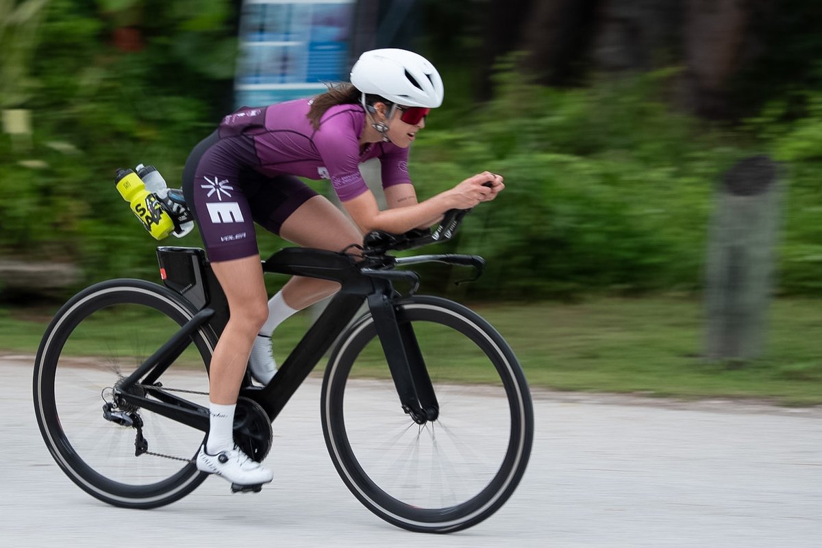 A cyclist riding in side profile, with Velora's joint markers and angle readouts drawn over her riding position.
